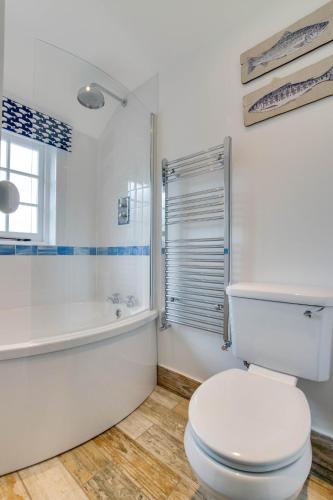 a white bathroom with a toilet and a bath tub at 1 Bed in Biddenden oc-cb635 in Biddenden