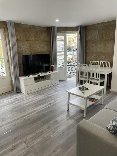 a living room with a flat screen tv and a couch at Ponte Romana in Chaves