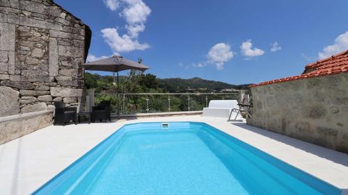 a swimming pool on the patio of a house at O Palheiro in Caramulo