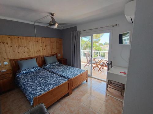 a bedroom with a bed and a view of a patio at Hostal Bélgica in Palmanova