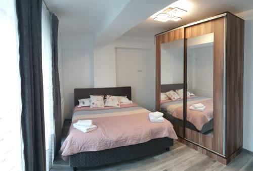a bedroom with two beds and a mirror at Apartament in Craiova