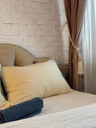 a bed with a white pillow and a brick wall at 1 Camera Dubla Valea Trandafirilor in Chişinău