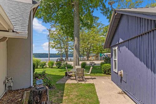 a backyard with a purple building and a table and chairs at Pet-friendly Cabin with Dock, Firepit, BBQ in Newaygo