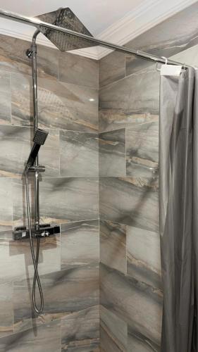a bathroom with a shower with a wooden wall at Beau studio cosy in Randens