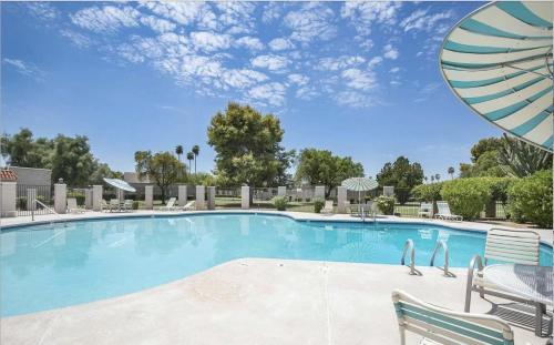 a large swimming pool with chairs and an umbrella at Old Town | Pool | BBQ | End Unit | Pet in Scottsdale