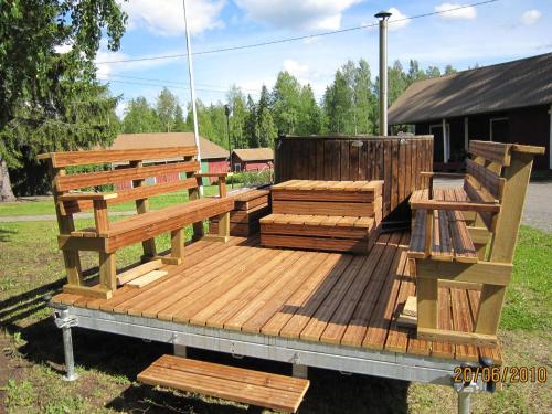a wooden deck with two benches on it at Holiday Home Tavintupa by Interhome in Pertunmaa