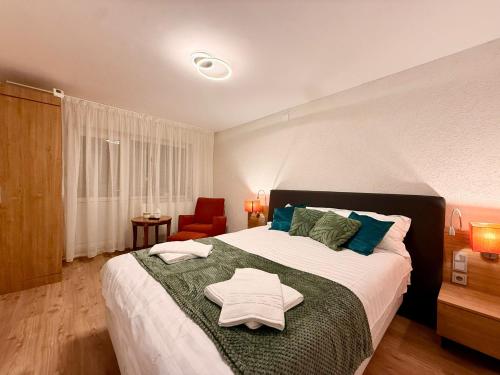 a bedroom with a large bed and a red chair at ADA Residence Lupeni acces rapid catre Straja Ski Resort in Lupeni