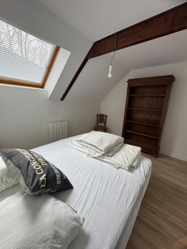 a bedroom with a bed with white sheets and a window at Les Vaillants Chalet - Vielle Aure in Vielle-Aure