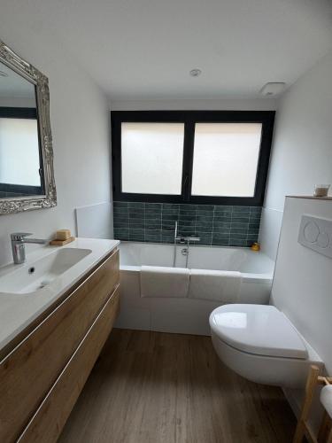 a bathroom with a tub and a toilet and a sink at Les Vaillants Chalet - Vielle Aure in Vielle-Aure
