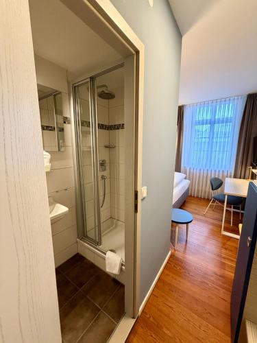 a bathroom with a shower and a glass door at Hotel Am Kornmarkt in Heidelberg