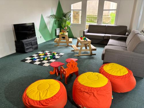a living room with orange and orange ottomans at Résidence Pierre & Vacances Ty Mat in Saint Malo