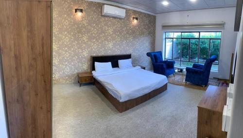 a bedroom with a bed and two blue chairs at Danzha Royal 4 in Erbil