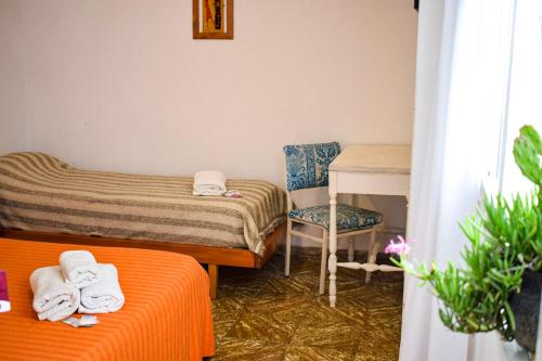 a room with two beds and a desk and a chair at Hotel Parque in Necochea