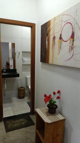 a bathroom with a table and a painting on the wall at Chalés do Valle - Arraial D'ajuda in Porto Seguro