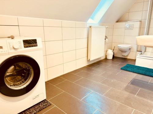 a laundry room with a washer and a toilet at Hotel Schneider Hof - Self-Check-In by RG Living in Bad Salzuflen