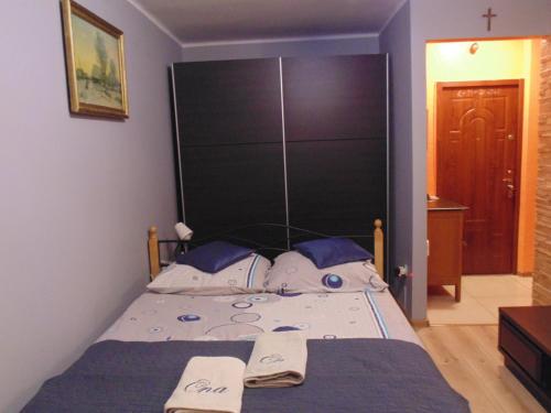a bedroom with a bed with a large black headboard at Nocleg u Mario in Uniejow