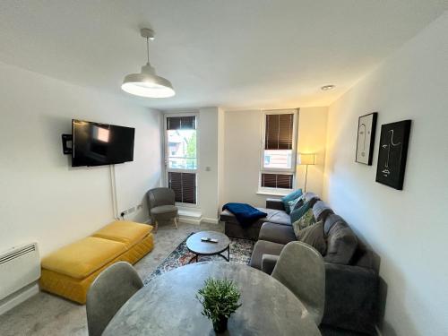 a living room with a couch and a table at 2 Bedroom, 2 Bathroom Modern Apartment close to Ocean Village, Free parking, Single or Double beds in Southampton