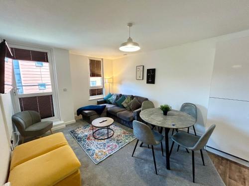 a living room with a couch and a table at 2 Bedroom, 2 Bathroom Modern Apartment close to Ocean Village, Free parking, Single or Double beds in Southampton