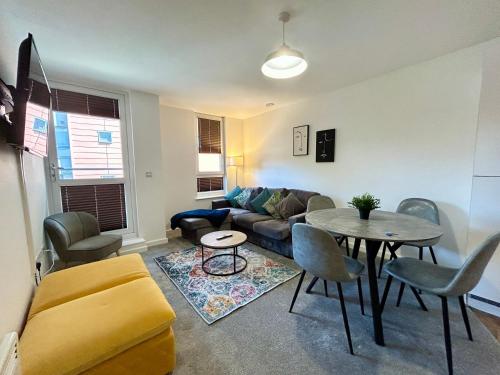a living room with a couch and a table at 2 Bedroom, 2 Bathroom Modern Apartment close to Ocean Village, Free parking, Single or Double beds in Southampton