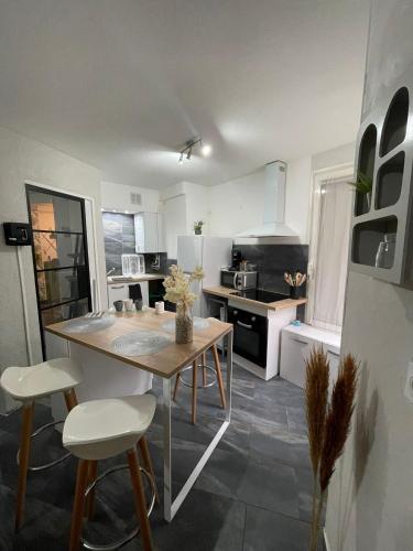 a kitchen with a table and chairs in a room at Oasis in Agen