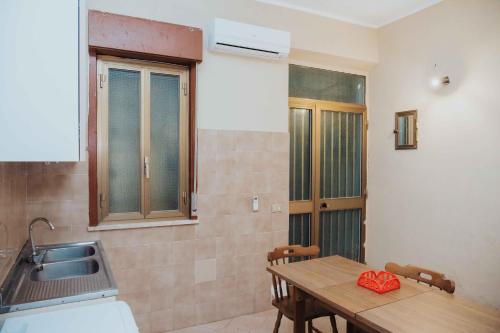 a kitchen with a wooden table and a sink at Tonnara Vista Mare in Palmi