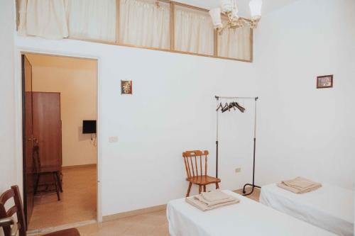 a white room with two beds and a chair at Tonnara Vista Mare in Palmi