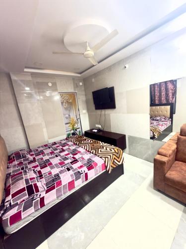 a bedroom with a bed and a couch and a tv at Santhosh hotel in Khammam