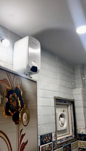 a public bathroom with a hair dryer on the wall at Santhosh hotel in Khammam