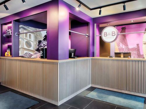 a lobby with purple walls and a sign that reads bc at B&B Hotel Augsburg-West in Augsburg