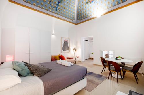 a bedroom with a bed and a table and chairs at Dimora Delle Stelle - Design & Heritage in Bari