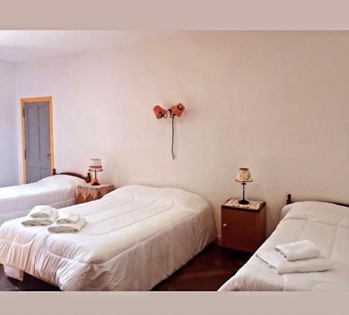 a room with two beds and a fan on the wall at Munay Posada in Los Cocos