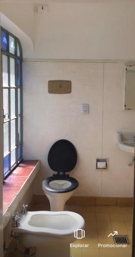 a bathroom with a toilet with a black seat at Munay Posada in Los Cocos