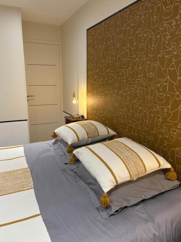 a bedroom with a bed with a large headboard at Villa Le Rubis in Agon-Coutainville