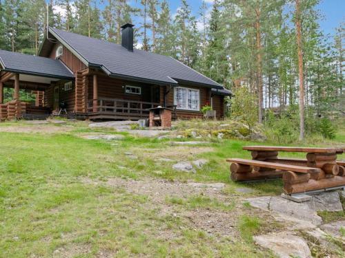 a log cabin with a picnic table in front of it at Holiday Home Ulappa by Interhome in Hurissalo