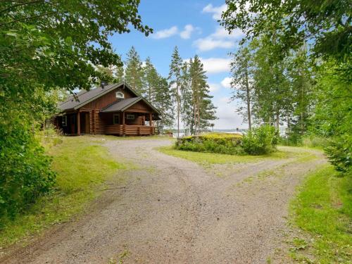 a dirt road leading to a log cabin at Holiday Home Ulappa by Interhome in Hurissalo