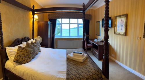 a bedroom with a canopy bed and a window at Buckatree Hall Hotel in Telford