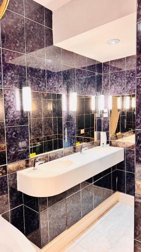 a bathroom with a sink and a large mirror at Buckatree Hall Hotel in Telford