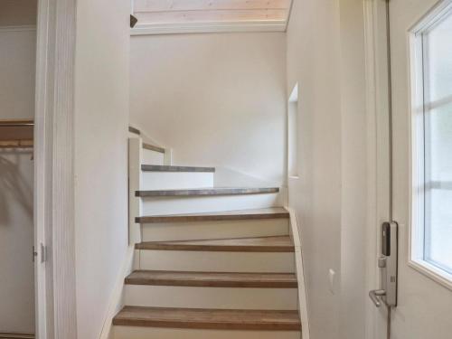 a staircase in a house with white walls and a window at Holiday Home Pikkuhukka by Interhome in Hyrynsalmi