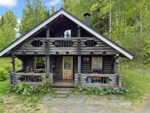 a log cabin in the woods with a porch at Holiday Home Heinäsorsa by Interhome in Rutalahti