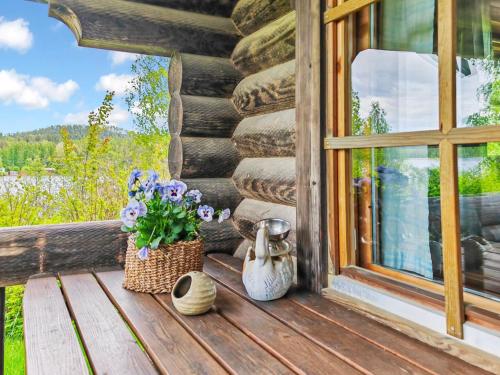 a porch of a log cabin with flowers and a window at Holiday Home Heinäsorsa by Interhome in Rutalahti