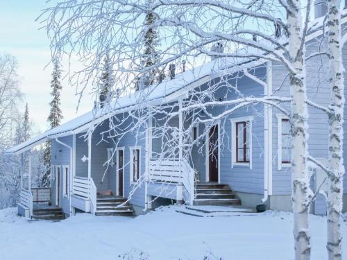 a blue house with snow on the porch at Holiday Home Pulkka 2 by Interhome in Salla