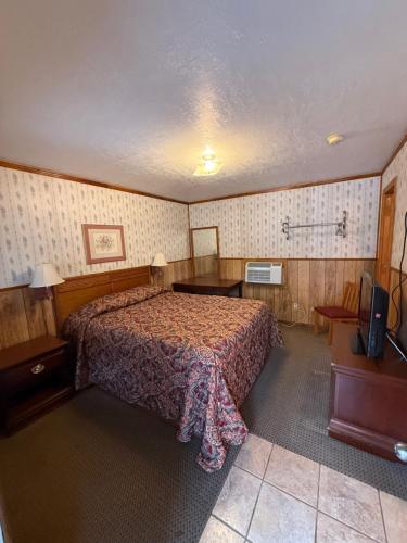 a bedroom with a bed and a television in it at Angelina Motel in Lufkin