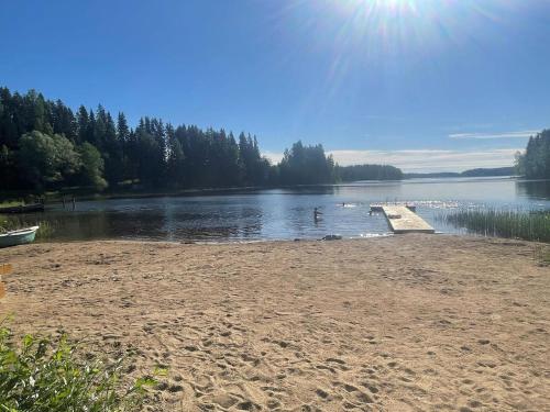 a beach with a dock in the middle of a lake at Holiday Home Metsäpirtti by Interhome in Vaskivesi