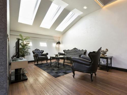 a living room with black chairs and a table at Nova City Garni Hotel Signature Collection in Belgrade