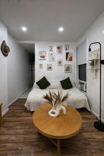 a bedroom with a bed and a table in front of it at Next to Manhattan 2 Bedrooms Apartment - Subway 20 steps, Manhattan 1 Stop in Roosevelt Island