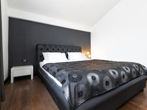 a bedroom with a large bed with a black headboard at Nova City Garni Hotel Signature Collection in Belgrade