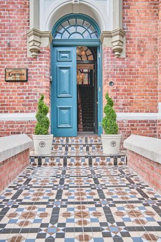 a blue door on a brick building with two plants at The Lawrence in Derry Londonderry
