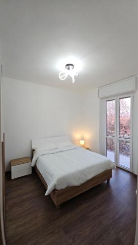 a white bedroom with a large bed and a window at Casa Giovanni in Turin