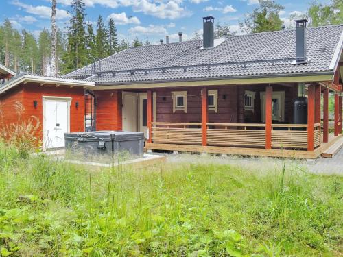 a wooden house with a porch and a yard at Holiday Home Villa utu by Interhome in Kolinkylä