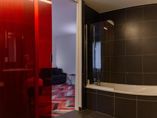 a bathroom with red and black tiles and a mirror at Best Western Hotel San Benedetto in Cholet